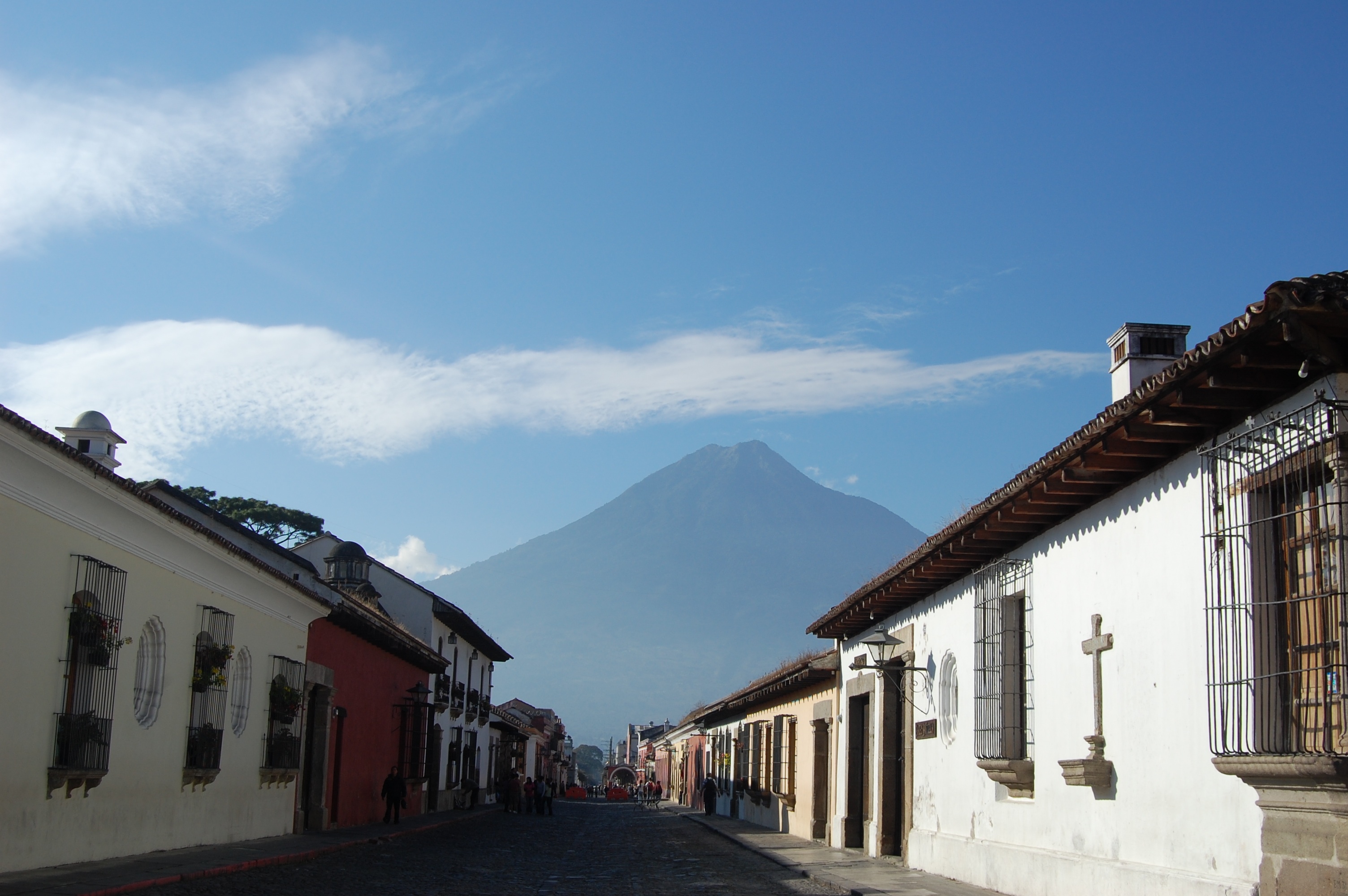 Street with beautiful Spanish colonial architecture and volcano looming in the distance.
